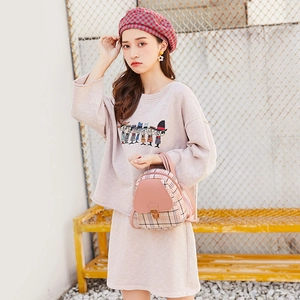 Dettaglio mini zaino a quadri rosa e berretto abbinato indossati da una modella di moda