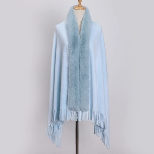 Detail of light blue winter shawl featuring faux fur collar and elegant tassel trim