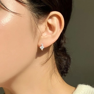 Close-up of minimalist 925 sterling silver square zircon stud earring on female ear