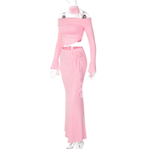 Detailed view of pink rib-knit two-piece set with floral accent and ruffle trim