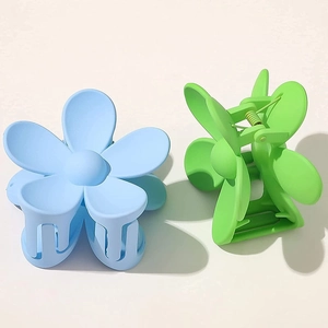 Matte daisy flower hair claws in blue and green colors for women on a white background