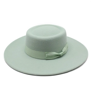 Detailed texture of mint green wool felt flat top boater hat with matching ribbon bow