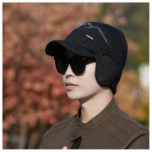 Close-up of winter knit hat with earflaps and brim featuring the NY and JA brand label
