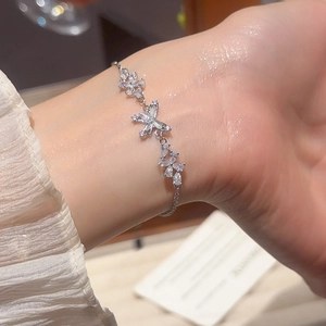 Close-up of 18k gold plated butterfly and flower bracelet with sparkling cubic zirconia