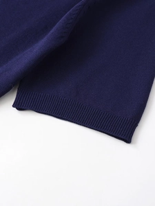 Detail of navy blue wool knit cardigan showing fine ribbed cuffs and premium texture