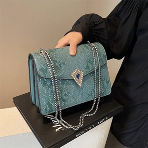 Teal snake-pattern crossbody bag with silver chain strap and diamond buckle detail