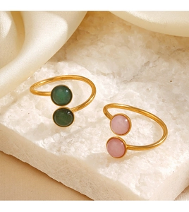 Detail of gold open rings featuring green aventurine and pink quartz gemstones