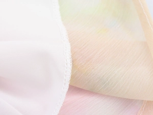 Dettaglio del tessuto in chiffon sfumato con cuciture taglia-cuci di qualità e trama leggera