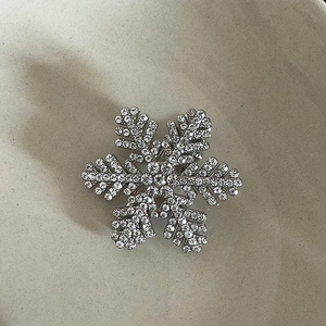Close-up of a silver snowflake hair clip with intricate sparkling crystal settings