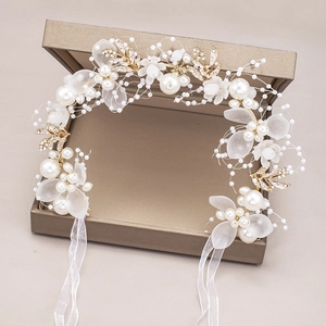Elegant bridal hairband with white pearls and matte flowers in a golden jewelry box