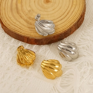Gold and silver seashell earrings made of stainless steel displayed on a wood slice