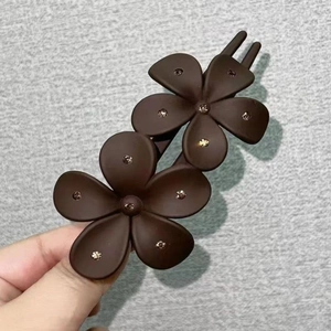 Close-up of dark brown floral hair clip with inlaid sparkling rhinestones for women
