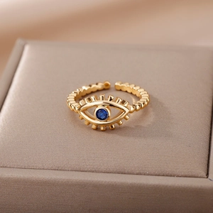 Macro shot of gold-plated evil eye ring featuring blue gemstone and beaded band