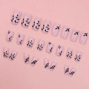 Pink press-on nail set with black floral branch patterns and glossy finish, 24 pieces