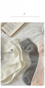 Detail view of cotton socks with rib texture and delicate black bow embroidery