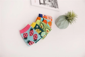 Détail de cinq paires de chaussettes en coton avec des motifs de fruits comme l'avocat et la pêche