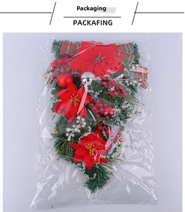 Detailed view of artificial Christmas poinsettia teardrop wreath in OPP plastic packaging