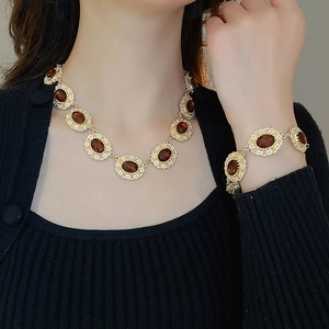 Close-up of vintage gold flower jewelry set with brown oval gems and white diamonds