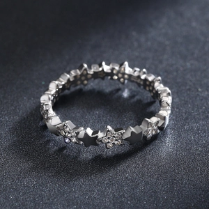 Sparkling S925 sterling silver ring with star design and embedded zircons on dark background
