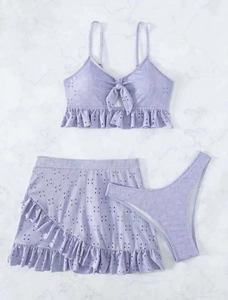 Detailopname van een lila driedelig bikinisetje met geborduurde bloemen en ruches