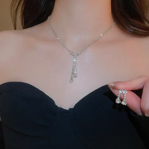 Detail view of silver rhinestone jewelry set with Y-shaped necklace and matching earrings