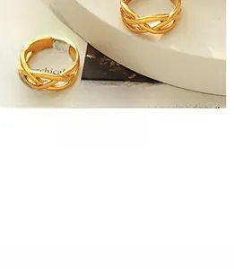 Detail of vintage woven gold layered rings on art book for a bohemian jewelry aesthetic