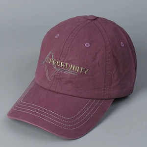 Detailed embroidery of gold letters on washed purple cotton canvas baseball cap