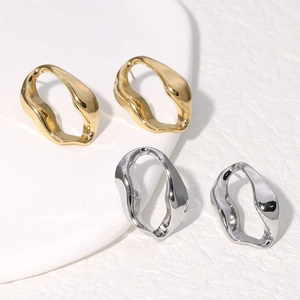 Irregular wave design titanium steel earrings in gold and silver finish set on white stand