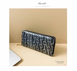 Detail of long PU leather purse with chain print pattern and gold zipper closure