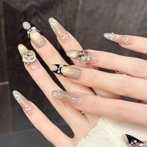 Luxurious champagne gold cat eye press-on nails with large crystals and silver butterflies