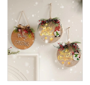 Detailed close-up of three wooden Christmas ornaments with pine needles and berries