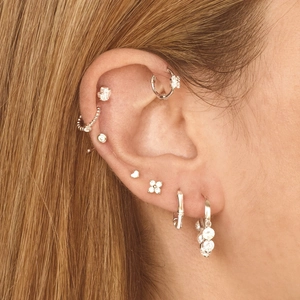 Elegant s925 silver heart and clover stud earrings set on ear model with zircons