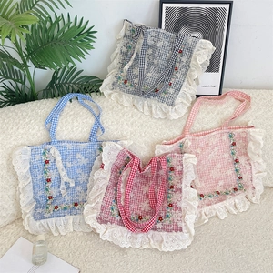 Detail showing checkered floral embroidery canvas bags with delicate lace trim