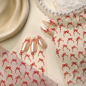Autocollants à ongles nœuds rouges minimalistes avec finition nacrée sur faux ongles