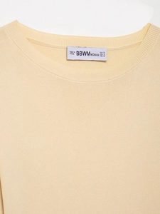 Close-up of cream ribbed knit top neckline with BBWM brand label and size details