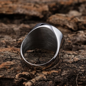 Polished silver stainless steel Knights Templar cross ring on a textured wood background