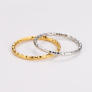 Set of gold and silver minimalist rings with textured finish on a clean white background