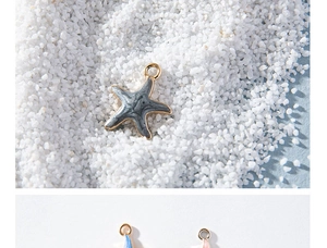 Detailed macro view of multi-colored starfish alloy pendants with enamel coating on white sand