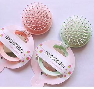 Pink and mint green foldable pocket hairbrush with mirror and strawberry packaging