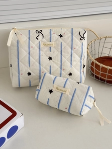 Detail of quilted makeup bags with blue star patterns and pink heart ribbon pullers