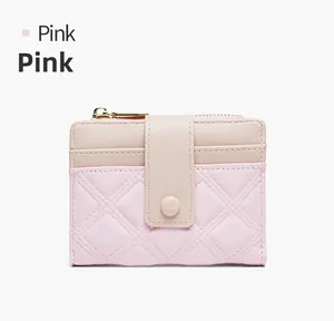 Detail of pink quilted short wallet with bicolor design and secure gold zipper closure