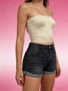 Detail shot of distressed dark grey denim shorts with frayed edges and ripped finish