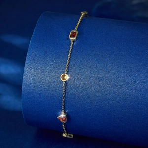 Elegant S925 silver gold bracelet with colorful geometric zircons on a blue display stand