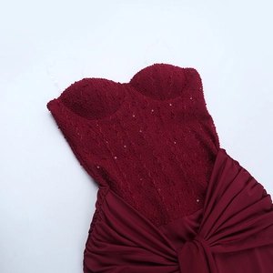 Detail of burgundy evening dress with sequin lace bodice and pleated satin skirt fabric