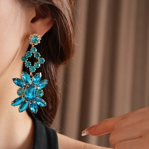 Gros plan de boucles d'oreilles vintage en strass bleus au design floral en losange