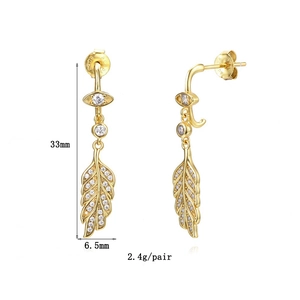 Detail view of gold feather earrings with cubic zirconia and size dimensions 33mm by 6.5mm