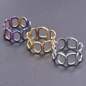 Close-up of geometric hollow chain rings in rainbow, gold, and silver finishes