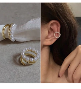 Detail view of 14k gold-plated pearl ear cuff on fabric and worn on the ear