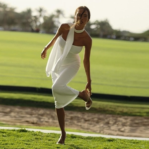Outdoor view of white bodycon maxi dress featuring a chic neck scarf and strapless design