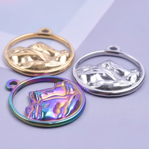 Macro shot of 18K stainless steel mountain charms in gold, silver, and rainbow finishes